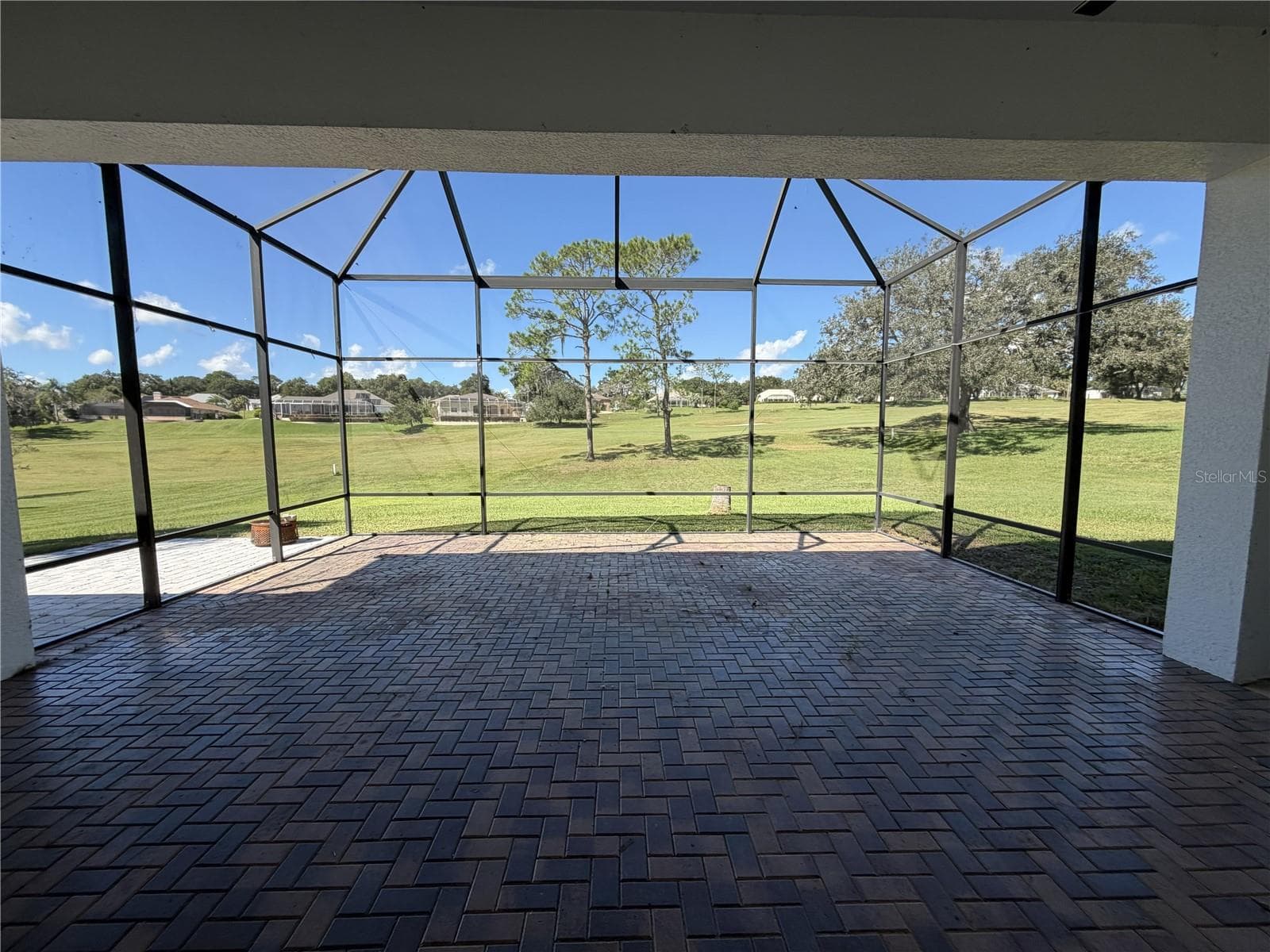 Large screened lanai with brick pavers and golf-course views. - 39539 HARBOR HILLS BLVD, LADY LAKE