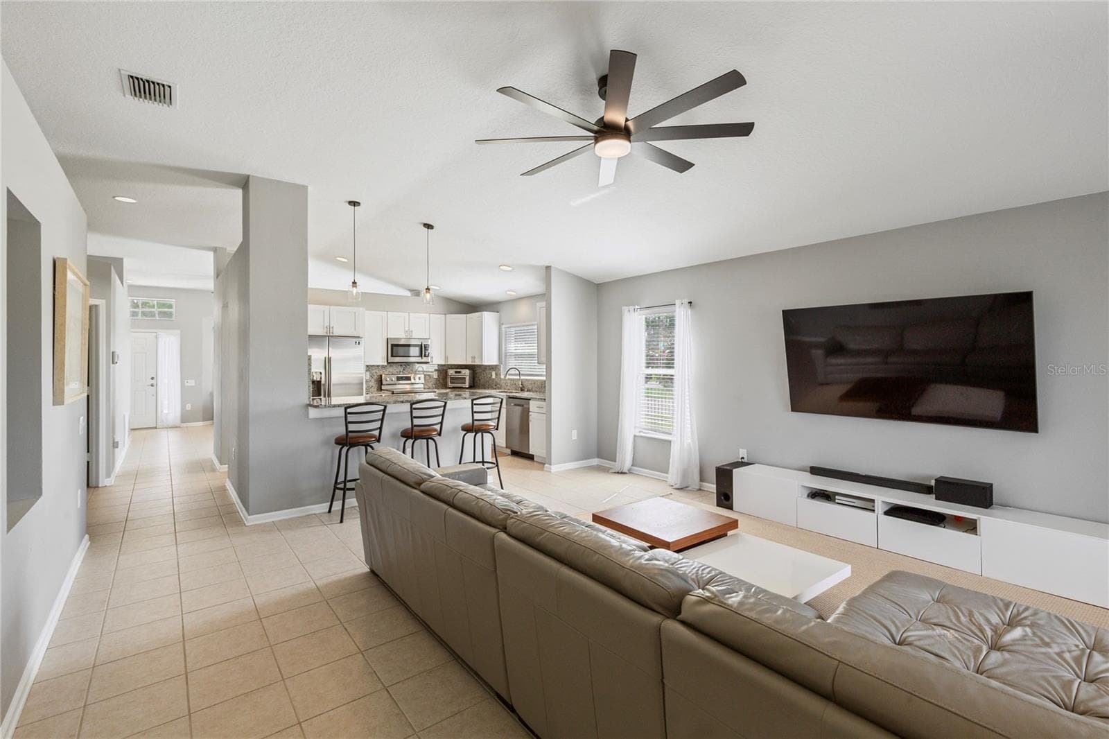 Indoor and Outdoor flow to living, dining, and kitchen - 7619 CRESCENT PALM DR, WESLEY CHAPEL