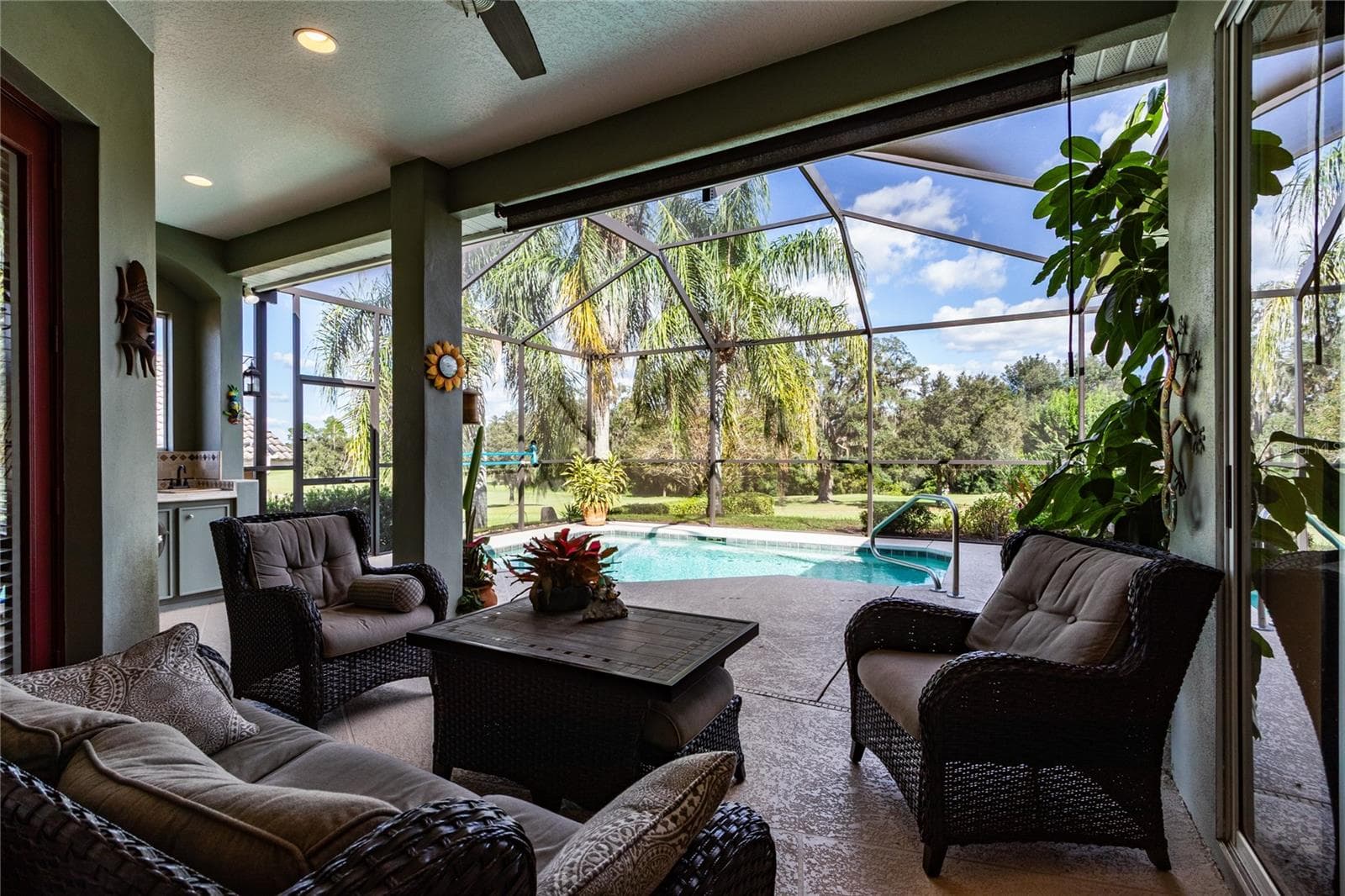 Covered lanai with fan overlooks pool and golf course - 13030 GRAND TRAVERSE DR, DADE CITY