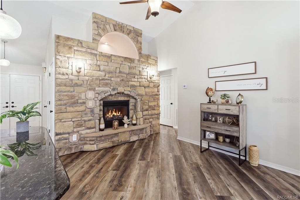 STONE-ACCENTED FIREPLACE- Impressive floor-to-ceiling stone-accented electric fireplace featuring a decorative arched opening & built-in hearth. - 1436 N CHERRY POP DR, HERNANDO
