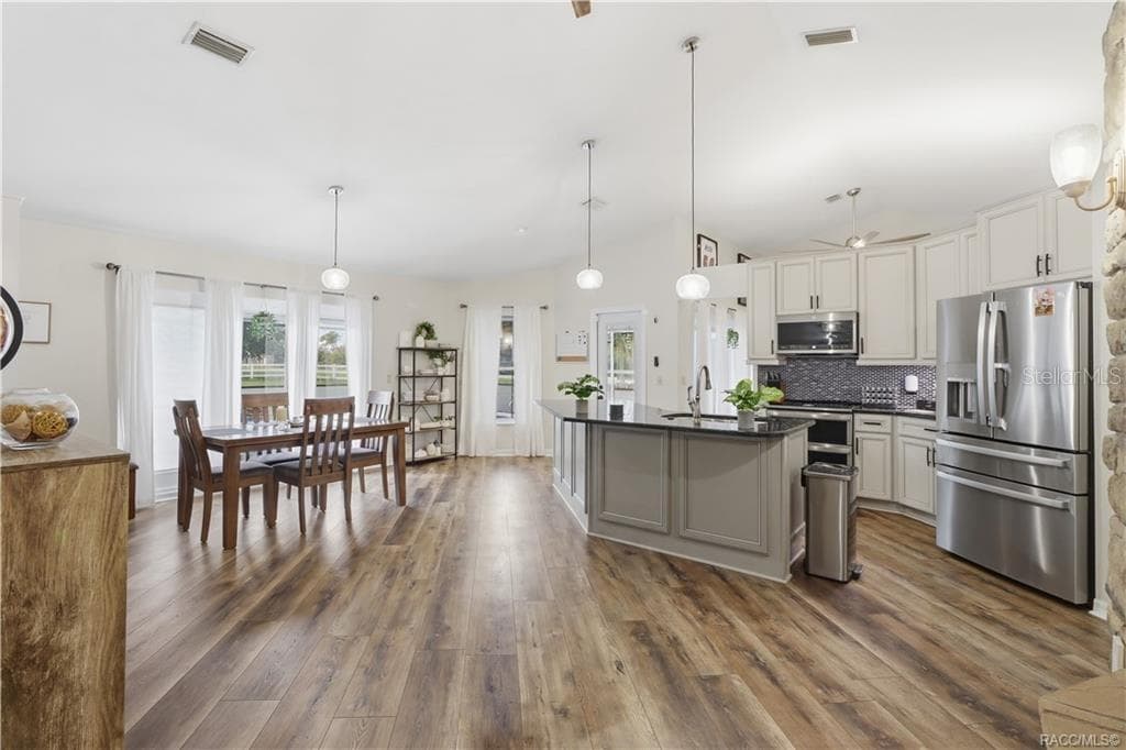 OPEN KITCHEN & DINING AREA- Beautiful open-concept kitchen & dining area featuring vaulted ceilings, granite countertops, center island & newer luxury vinyl flooring. - 1436 N CHERRY POP DR, HERNANDO