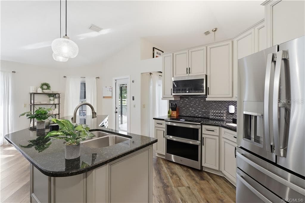 KITCHEN– Updated kitchen featuring NEWER STAINLESS STEEL APPLIANCES to include double oven, light-colored cabinetry, granite countertops & decorative ceramic tile backsplash. - 1436 N CHERRY POP DR, HERNANDO