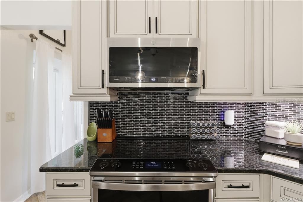 CERAMIC TILE BACKSPLASH- Close-up of the decorative black, gray & white CERAMIC MOSAIC TILE BACKSPLASH featuring a horizontal brick-pattern layout. - 1436 N CHERRY POP DR, HERNANDO