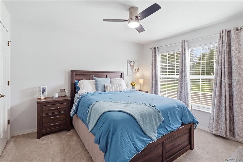 BEDROOMComfortable bedroom featuring neutral carpeting, ceiling fan & a large window overlooking the landscaped yard - 1436 N CHERRY POP DR, HERNANDO