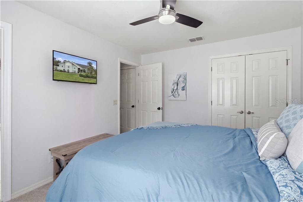 Bedroom – Bright, comfortable bedroom featuring neutral walls, carpeting, a ceiling fan & closet space. - 1436 N CHERRY POP DR, HERNANDO