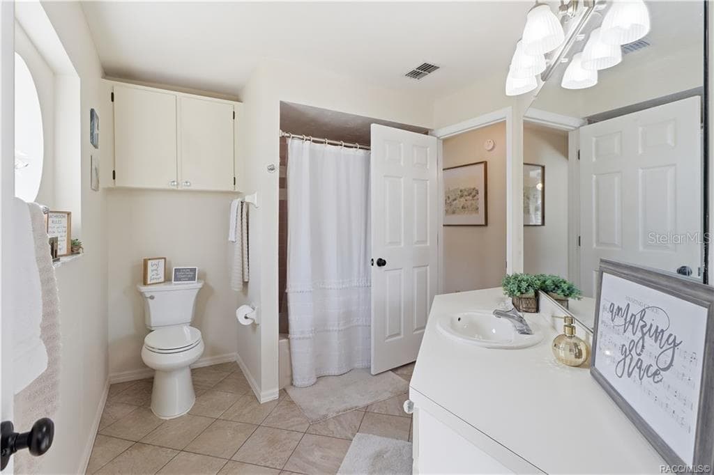 Guest Bathroom – Clean, inviting guest bathroom featuring a tub/shower combination, tile flooring, vanity & additional storage cabinetry. - 1436 N CHERRY POP DR, HERNANDO