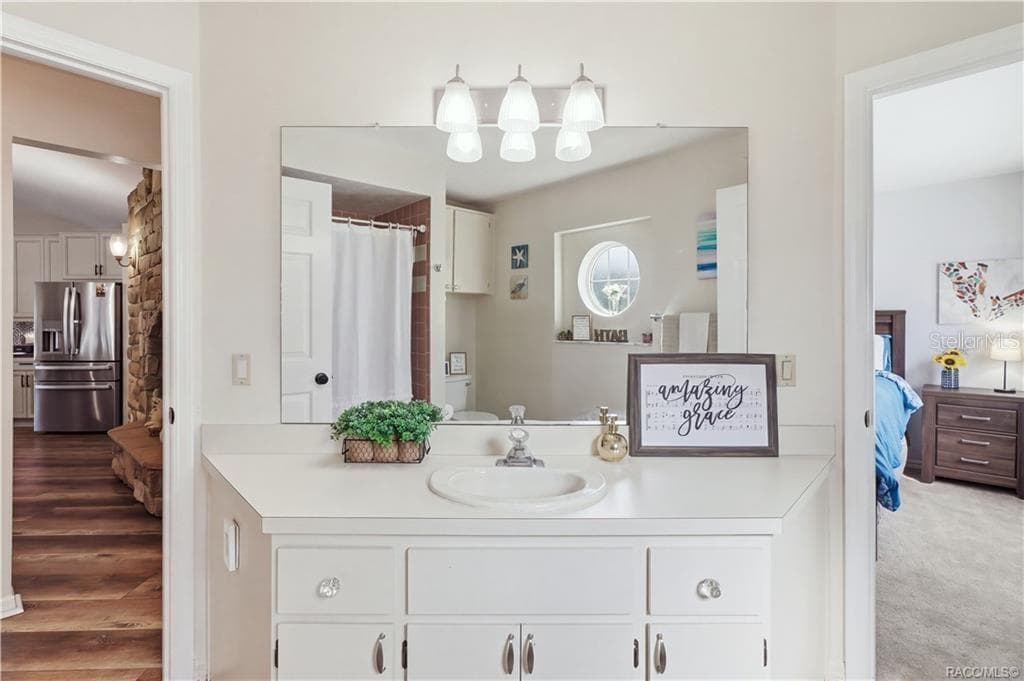 Guest Bathroom Vanity – Spacious vanity area w/a large mirror, countertop space & cabinetry for everyday storage. - 1436 N CHERRY POP DR, HERNANDO