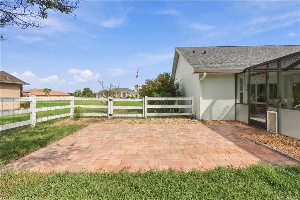 Outdoor Paver Patio – Open-air paver patio beside the pool enclosure, providing an additional spot for outdoor seating or entertaining. - 1436 N CHERRY POP DR, HERNANDO