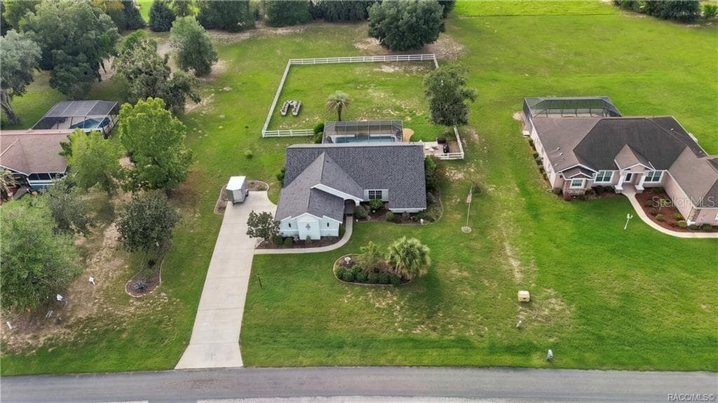 Aerial Property View – Beautiful overhead perspective showcasing the home, screened pool, white rail-fenced backyard & surrounding green space. - 1436 N CHERRY POP DR, HERNANDO
