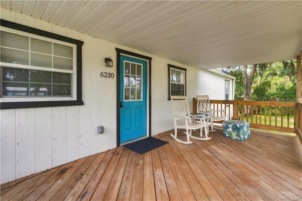 Front Porch Seating – A cozy place to relax, featuring wooden decking, a covered roof & room for rocking chairs to enjoy the Florida breeze. - 6230 W GLEN ROBBIN CT, CRYSTAL RIVER