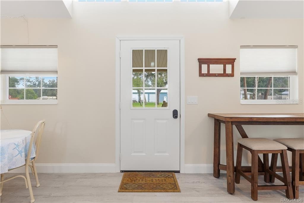 Front Entry – Bright & welcoming entrance featuring a glass-paneled front door, natural light, attractive flooring & space for additional seating. - 6230 W GLEN ROBBIN CT, CRYSTAL RIVER