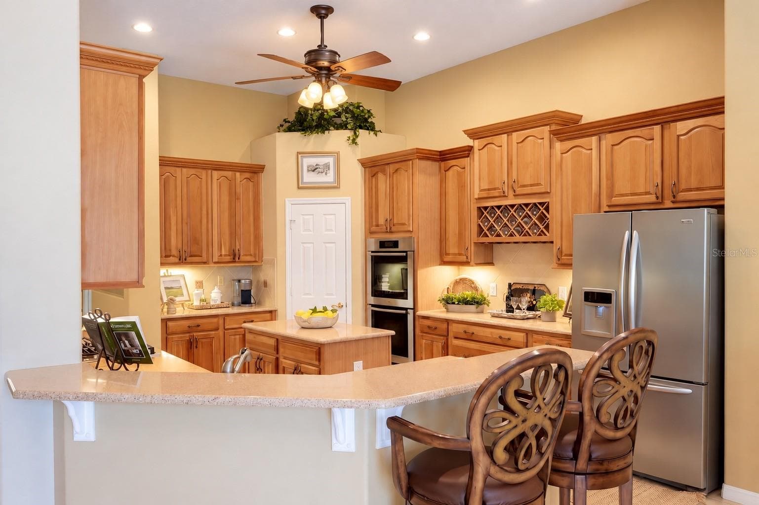 CENTER ISLAND, EXPANSIVE BREAKFAST BAR WITH SEATING, BUILT-IN DOUBLE OVENS, STAINLESS STEEL APPLIANCES, CUSTOM WINE RACK, AND CONVENIENT PANTRY! - 14542 RIVIERA POINTE DR, ORLANDO