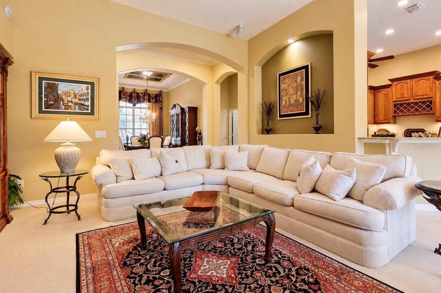 SPACIOUS AND INVITING FAMILY ROOM FEATURING SOARING CEILINGS, BEAUTIFUL ARCHITECTURAL ARCHWAYS, CUSTOM DECORATIVE WALL NICHE WITH ACCENT LIGHTING, AND AN OPEN-CONCEPT DESIGN! - 14542 RIVIERA POINTE DR, ORLANDO