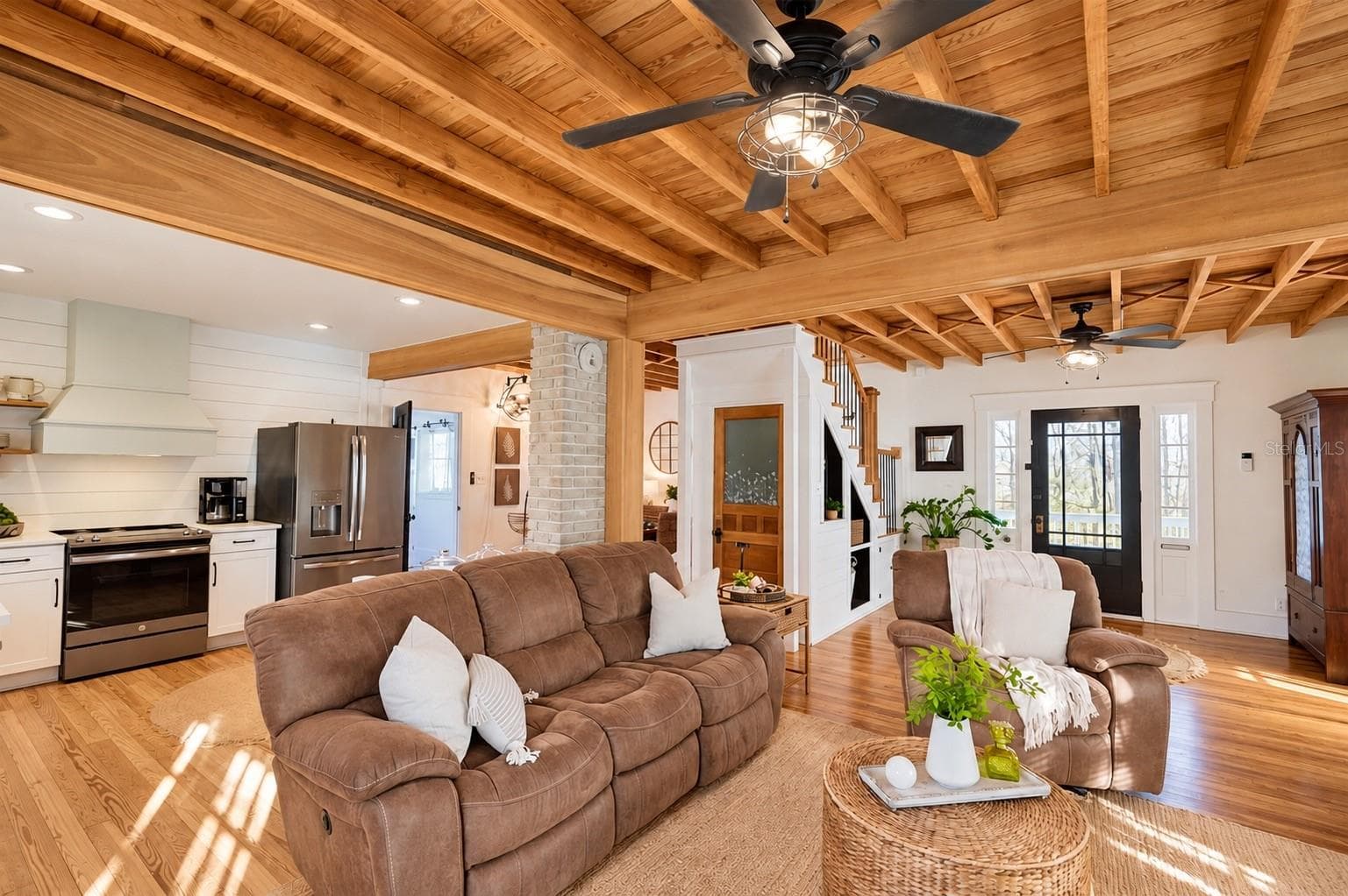 Beautiful OPEN-CONCEPT living area featuring stunning EXPOSED WOOD BEAM CEILINGS, gorgeous wood flooring, charming shiplap accents, and a seamless flow into the kitchen. - 1901 10TH ST, ST CLOUD