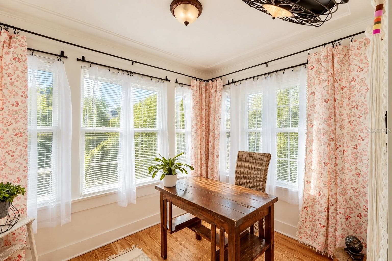 Bright and inviting SUNROOM featuring an abundance of natural light, beautiful hardwood floors, and DOUBLE FRENCH DOORS. Currently used as a home office, this versatile space offers endless possibilities as a guest room, reading retreat, or cozy sitting area! - 1901 10TH ST, ST CLOUD