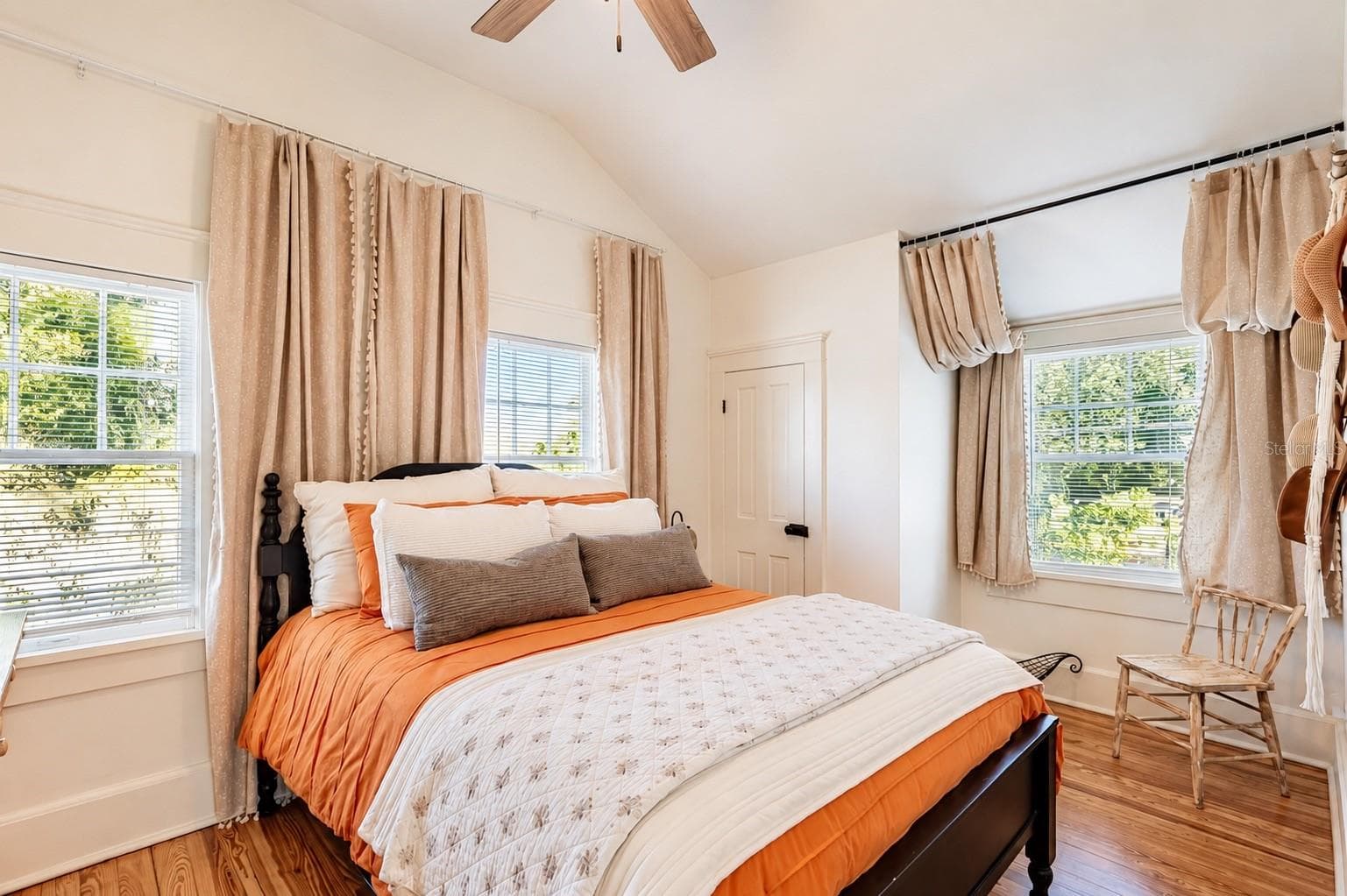Bright and inviting SECOND BEDROOM UPSTAIRS featuring vaulted ceilings, beautiful wood flooring, abundant natural light, ceiling fan, and a WALK-IN CLOSET. - 1901 10TH ST, ST CLOUD