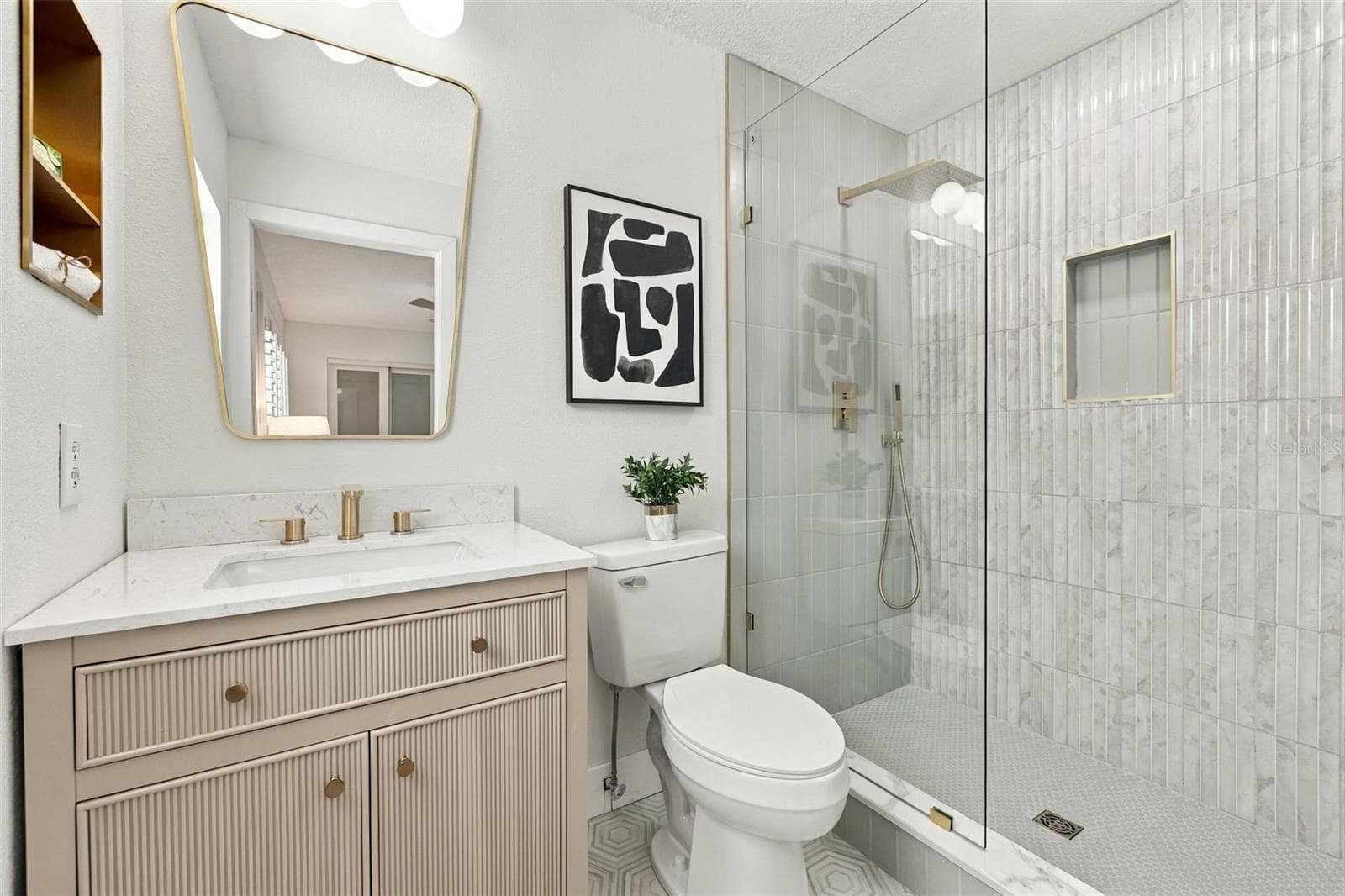 Primary bathroom with hexagon flooring, Quartz vanity, seamless glass shower with gleaming tile finish - 1613 GREENWOOD DR, DUNEDIN