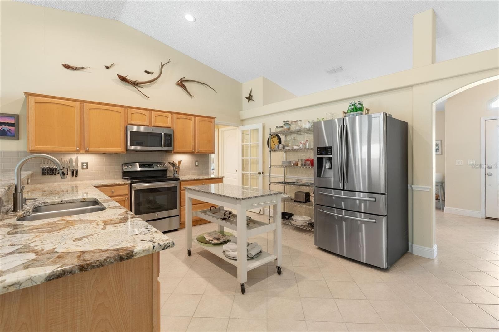 From preparing family favorites to trying new recipes, this kitchen makes everyday cooking a pleasure with beautiful granite countertops, stainless steel appliances, warm wood cabinetry, and a convenient movable island for added versatility. - 19 EDGELY LN, PALM COAST