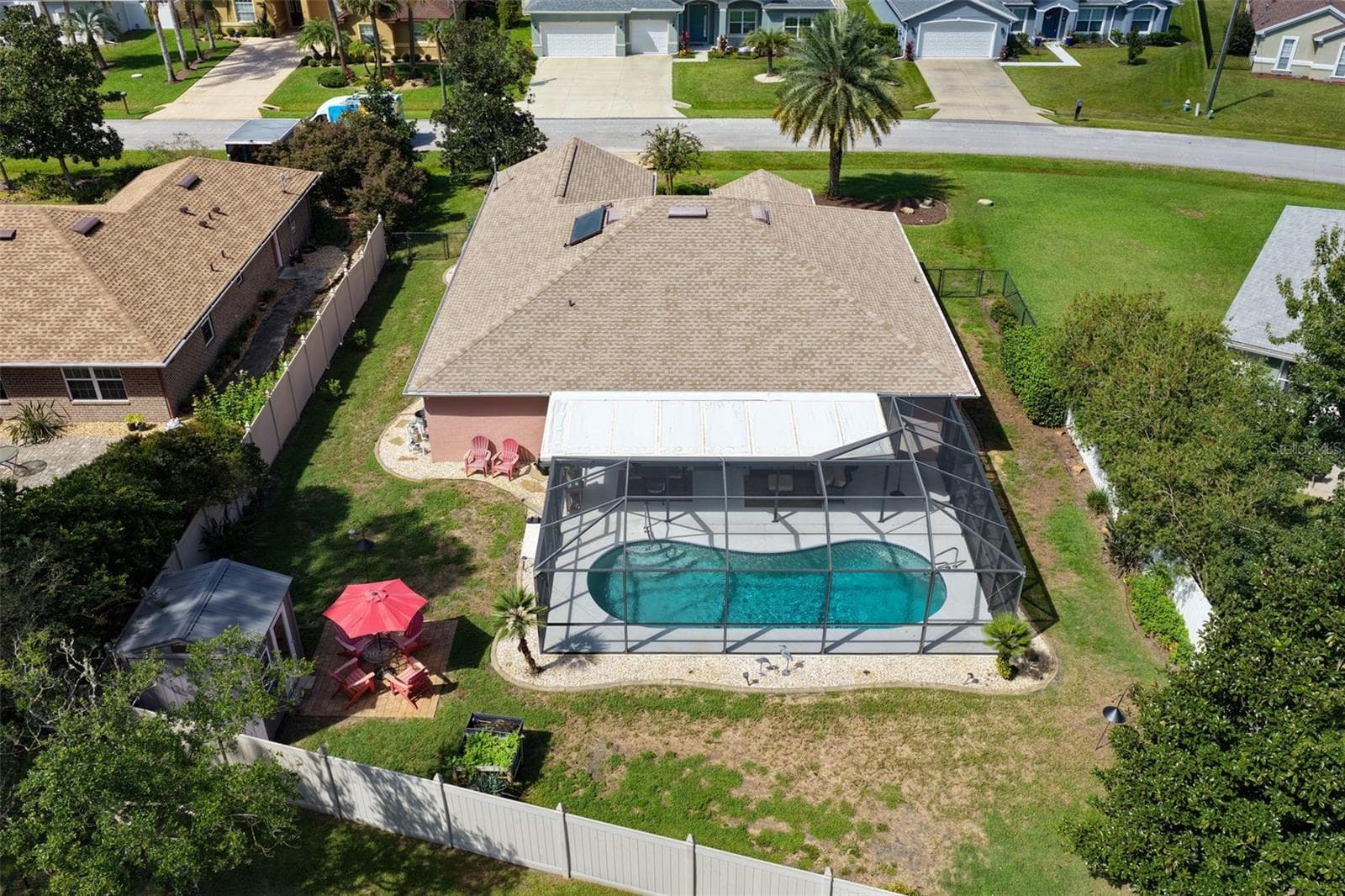 A backyard designed for making memories! This aerial view showcases the screened pool, spacious fenced yard, charming she shed, and outdoor gathering areas, offering plenty of ways to enjoy Florida living. - 19 EDGELY LN, PALM COAST