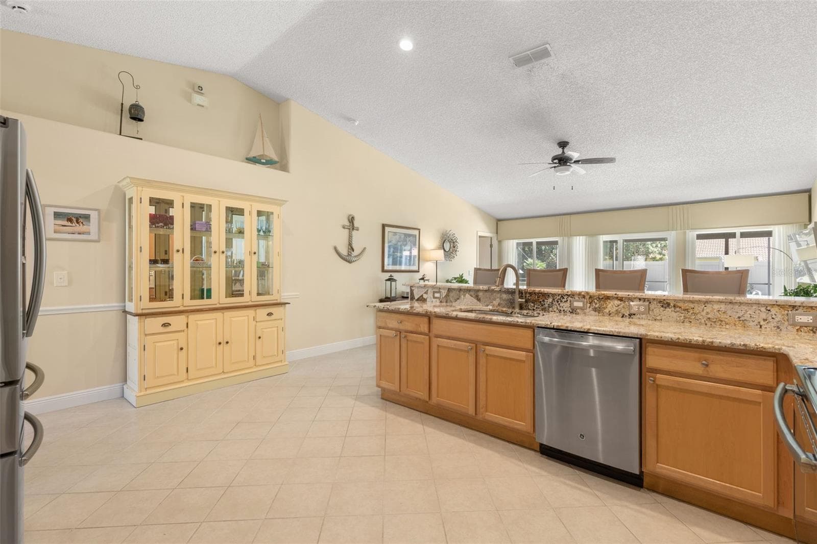 This view showcases the kitchen’s spacious, open layout, offering plenty of room to move around, while the elevated display shelf above the wall provides a distinctive spot for decorative accents and personal treasures. - 19 EDGELY LN, PALM COAST