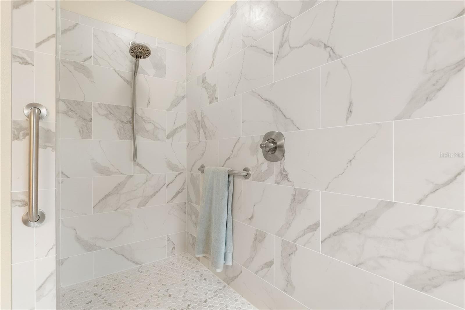 A little luxury goes a long way! The primary shower's generous walk-in design and convenient grab bar combine beautiful style with everyday practicality. - 19 EDGELY LN, PALM COAST