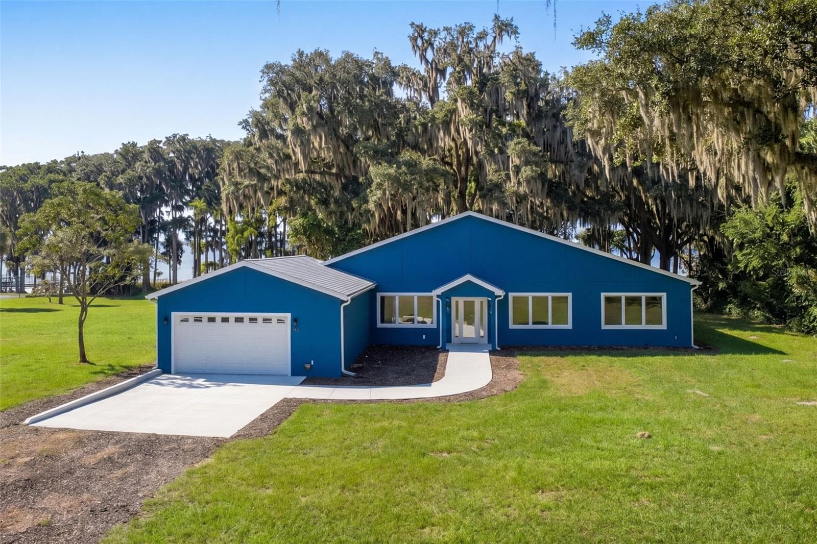 Welcome home: block and stucco, built 2025, set among moss-draped live oaks - 4410 CORLEY ISLAND RD, LEESBURG