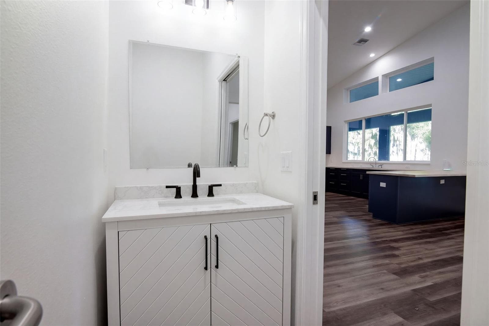 Guest half bath with chevron vanity and matte black fixtures - 4410 CORLEY ISLAND RD, LEESBURG
