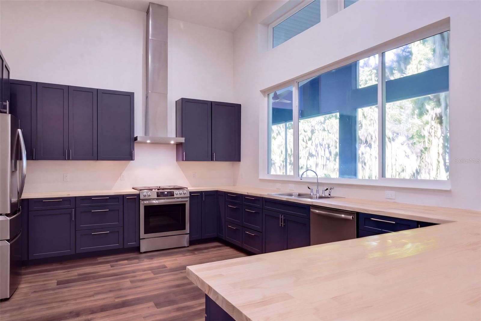 Stainless chimney hood, 5-burner propane range, and French door fridge - 4410 CORLEY ISLAND RD, LEESBURG