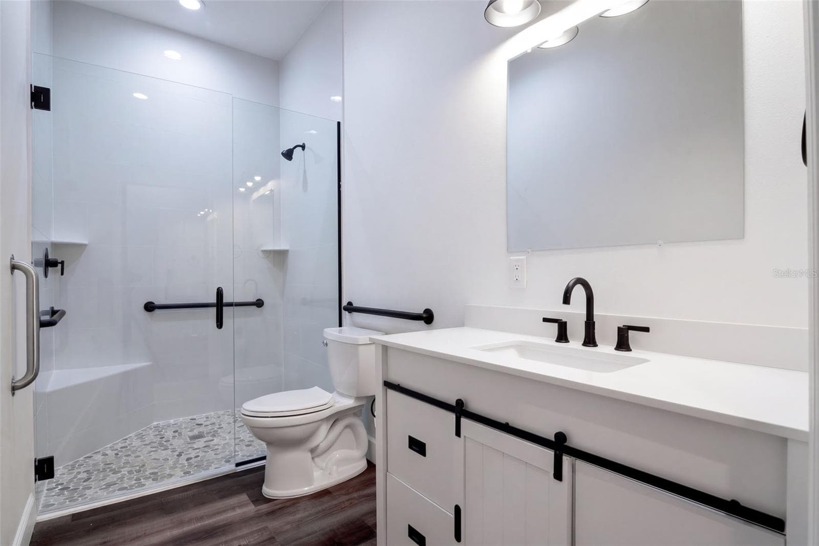 Guest bath with glass walk-in shower, grab bars, and matte black fixtures - 4410 CORLEY ISLAND RD, LEESBURG
