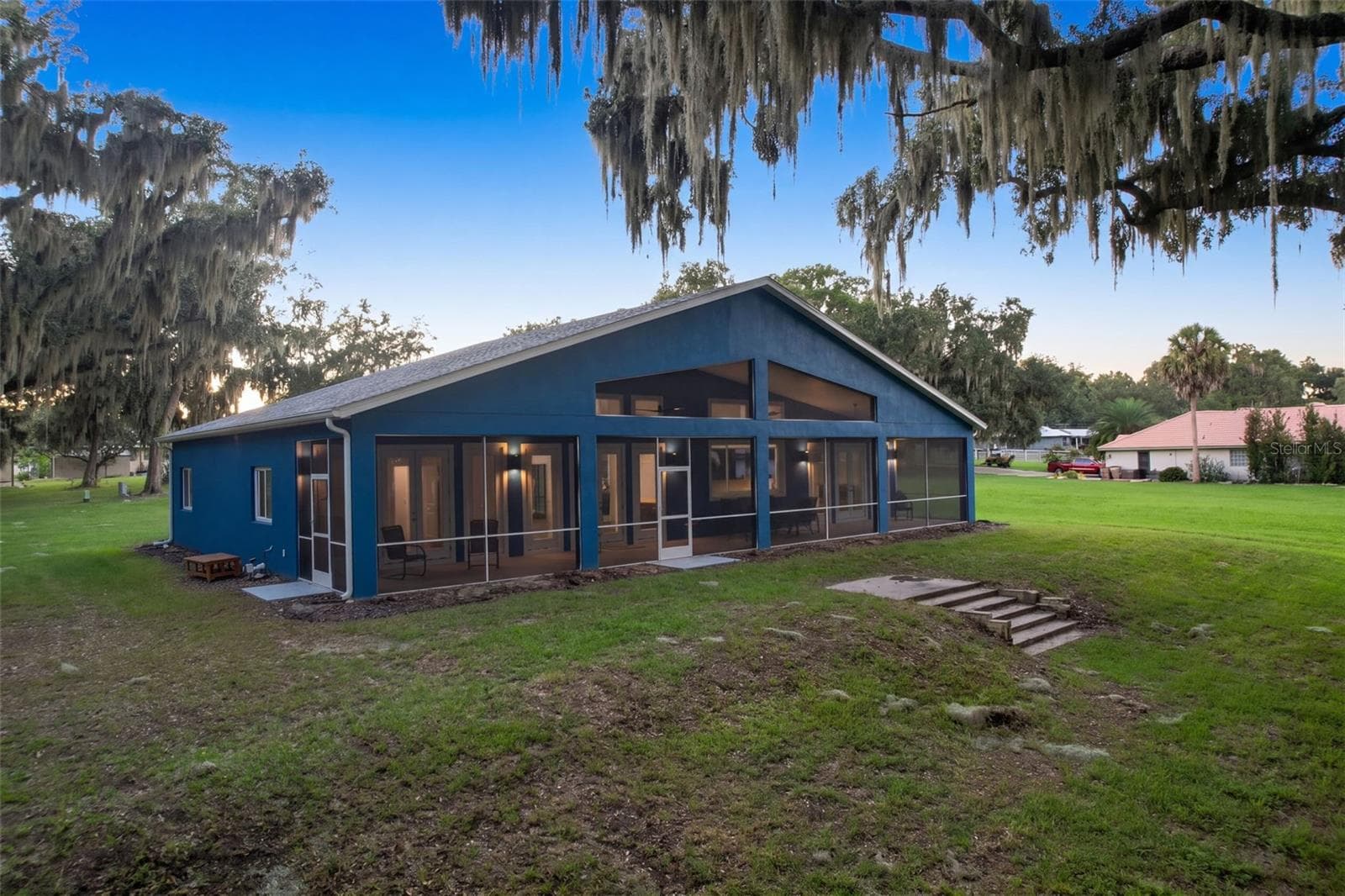 Back of the home: full-length screened porch facing east toward Lake Harris - 4410 CORLEY ISLAND RD, LEESBURG