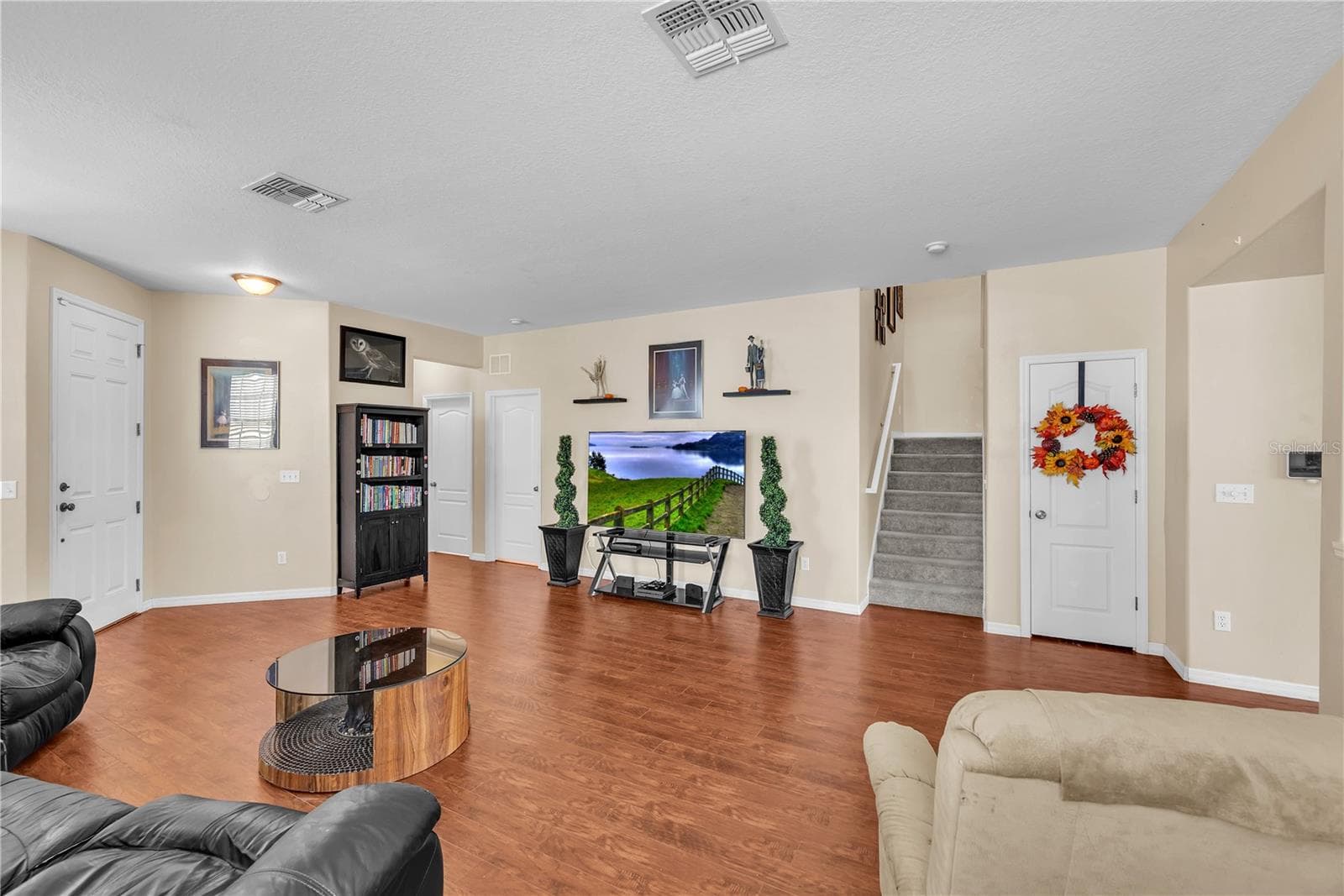 To the left of the TV is a hall leading to a first floor bedroom or flex space and full bathroom. - 18801 SUNTERRA DR, LAND O LAKES