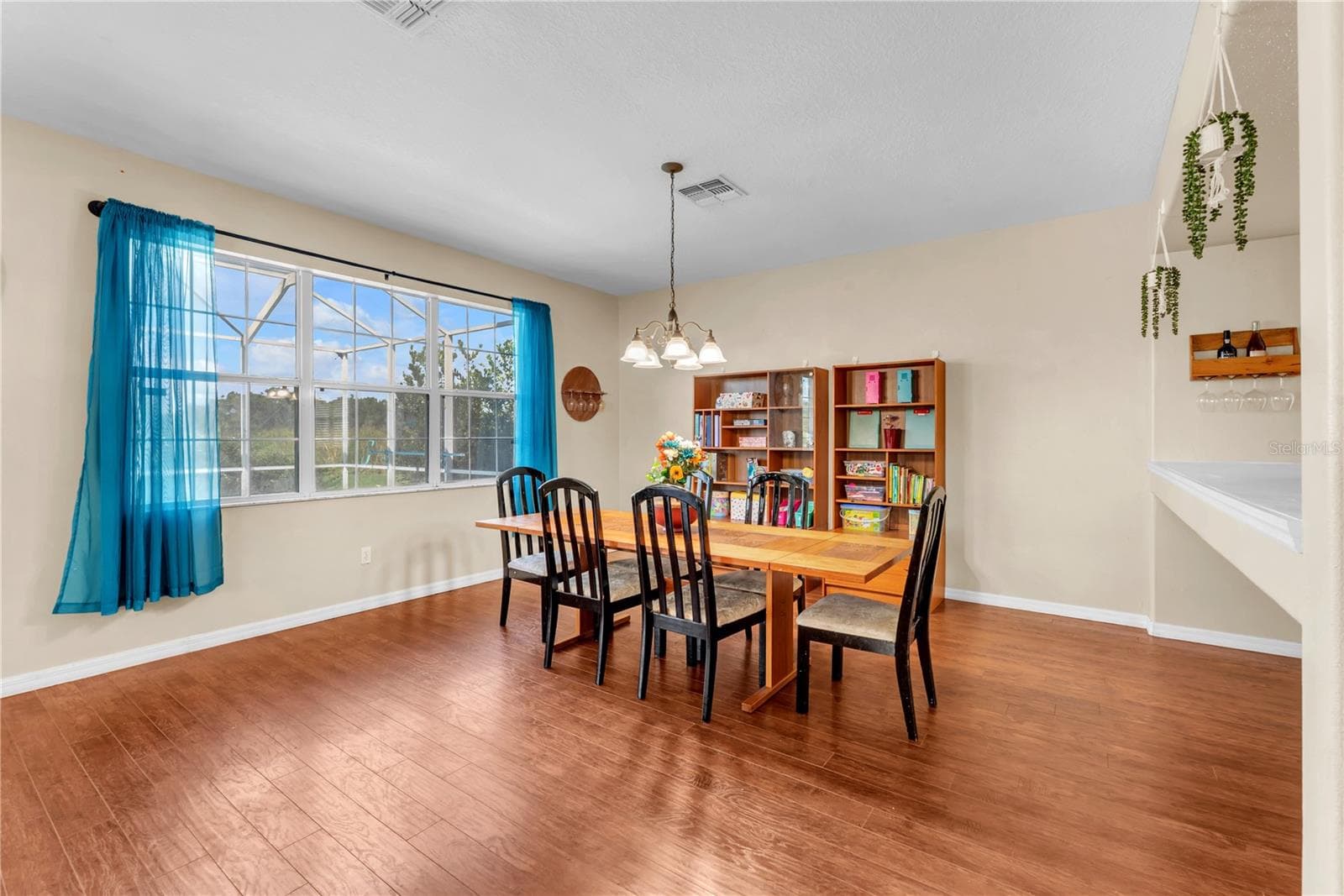 Large window overlooking the pool and lanai flood the dining area with natural light. - 18801 SUNTERRA DR, LAND O LAKES