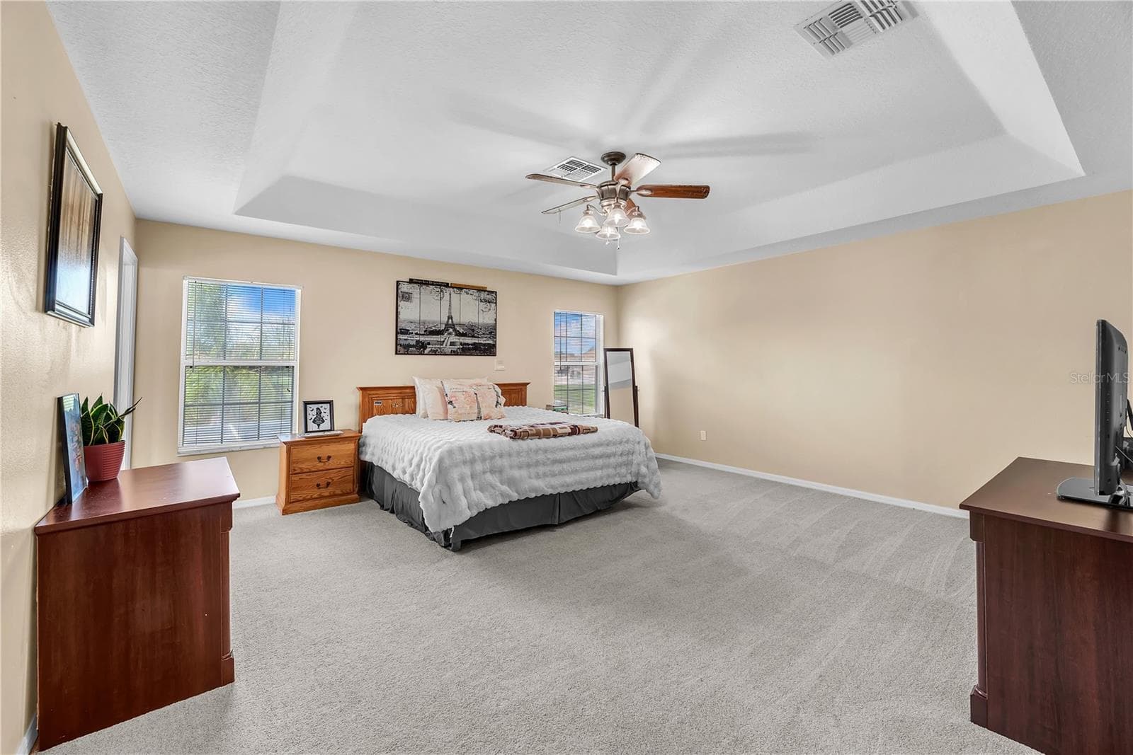 The spacious owner's suite has lots of natural light, a tray Ceiling detail and the Carpet was upgraded in 2021. - 18801 SUNTERRA DR, LAND O LAKES