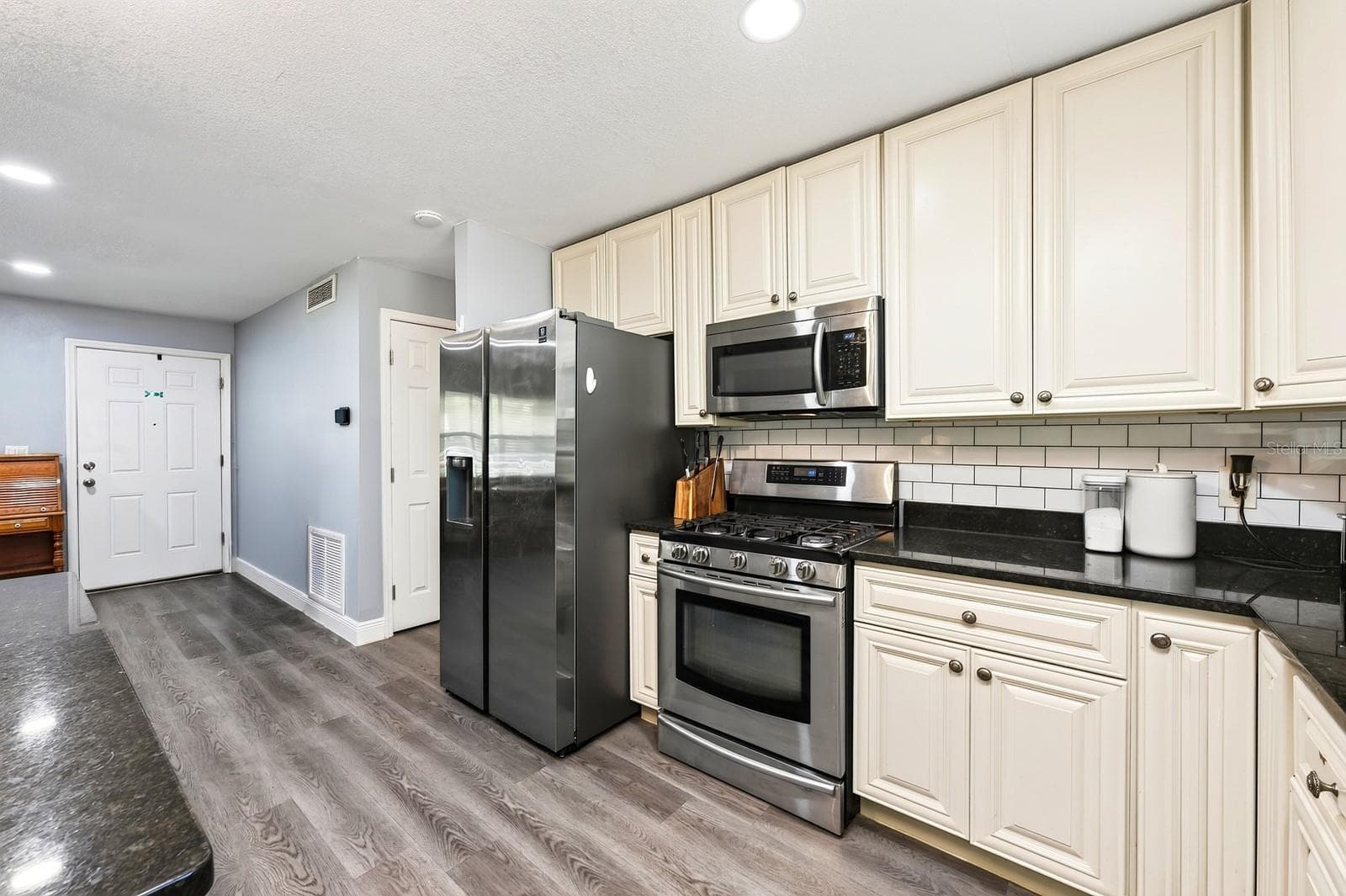 A RECENTLY UPDATED TILE BACKSPLASH adds a stylish finishing touch, while STAINLESS STEEL APPLIANCES—including a GAS STOVE—make meal preparation a pleasure. - 1444 KENNY CT, WINTER GARDEN