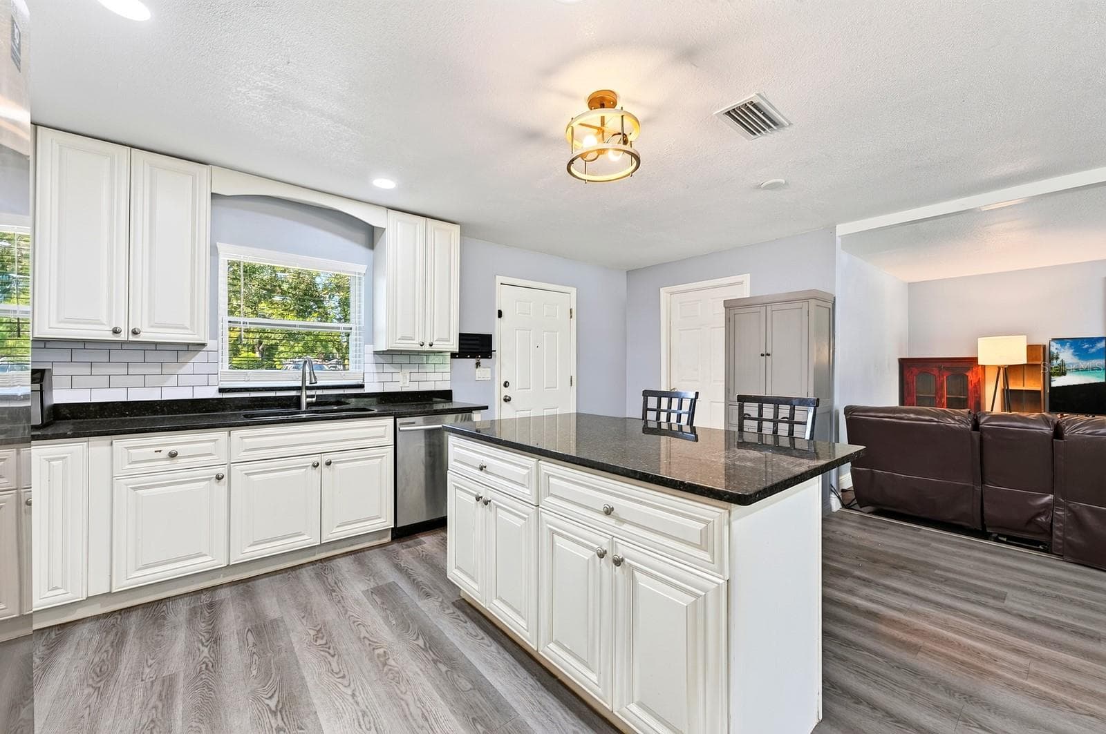 The Kitchen offers plenty of SOLID WOOD WHITE CABINETRY, solid-surface countertops and a center island with breakfast bar seating. - 1444 KENNY CT, WINTER GARDEN