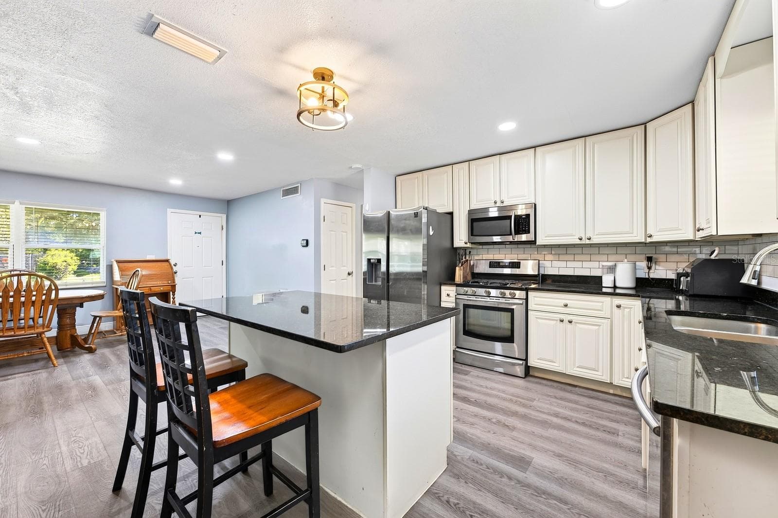 The Kitchen island provides extra prep space and room for counter-height seating. - 1444 KENNY CT, WINTER GARDEN