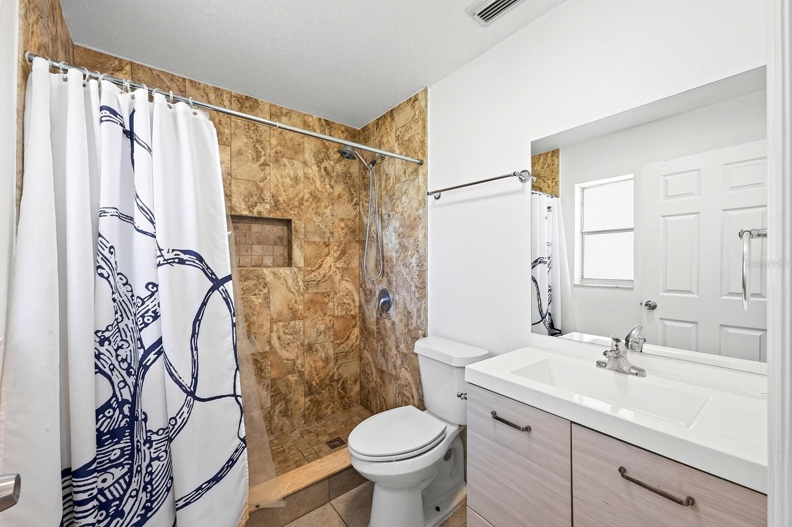 The Primary en suite is complete with a MODERN VANITY and TILED WALK-IN SHOWER. - 1444 KENNY CT, WINTER GARDEN