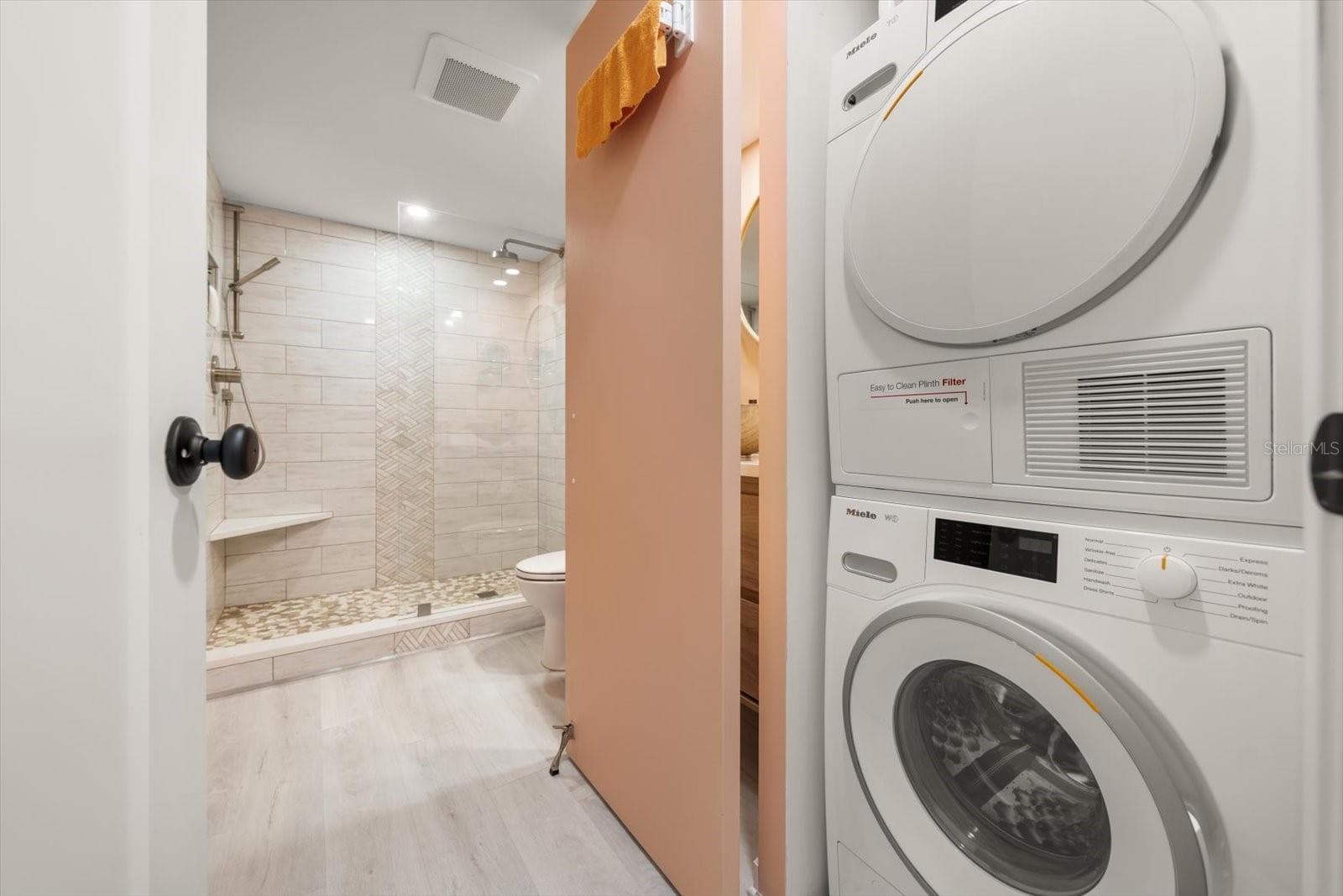 In unit Miele washing machine & dryer; discreetly tucked away in the guest bath. - 400 ISLAND WAY #904, CLEARWATER BEACH