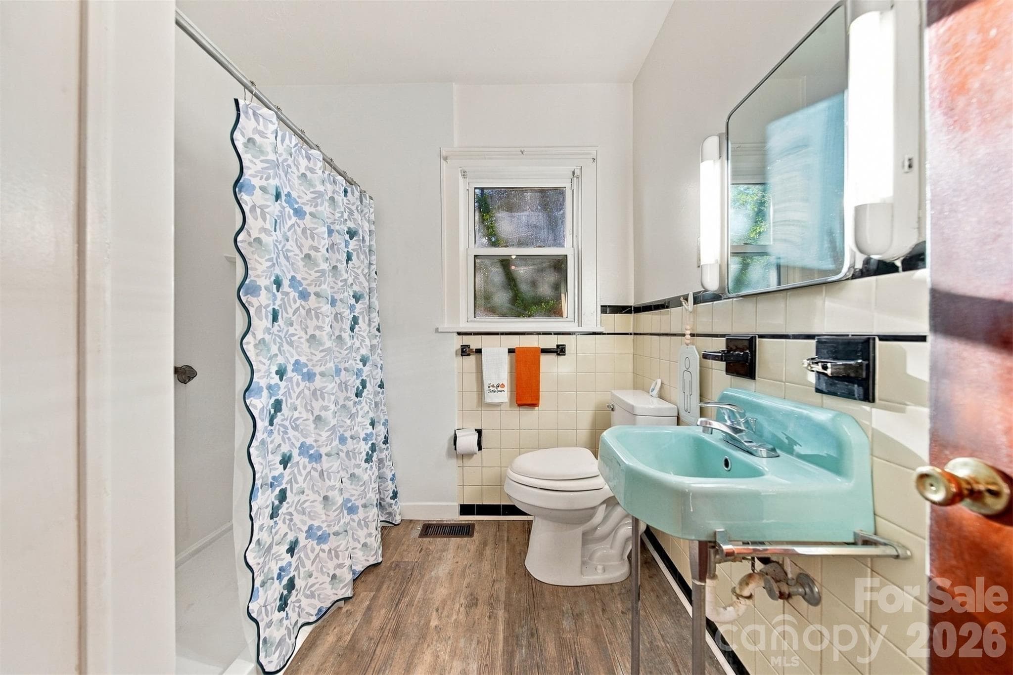 Bathroom has original retro sink and a step-in shower with grab bars. Vinyl flooring. New toilet - 203 W 21st Street, Newton