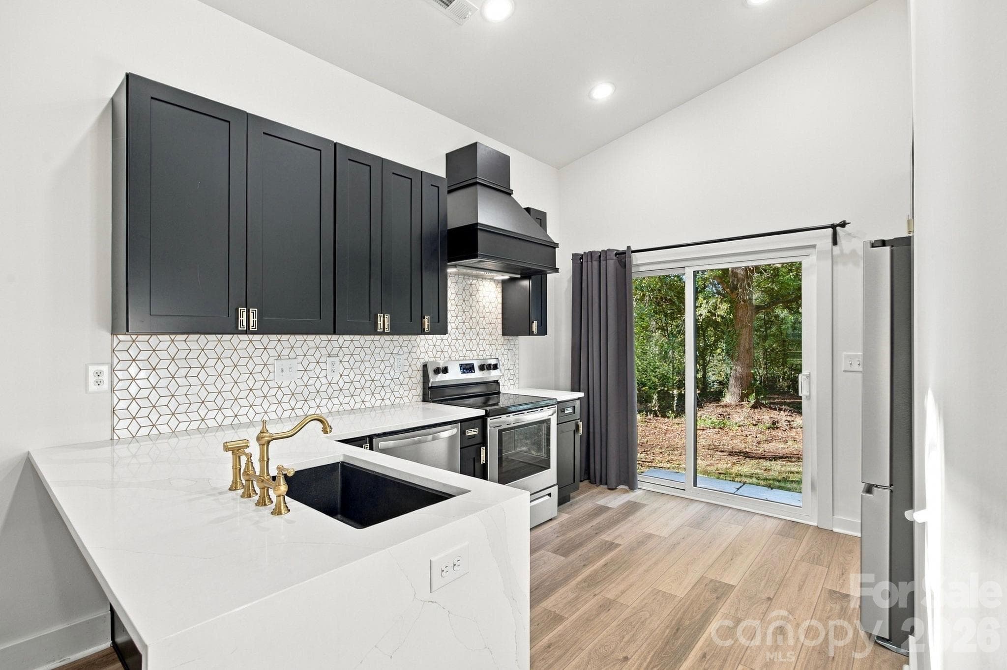 Kitchen with breakfast bar and sliding doors to the backyard - 571 Buford Drive SW, Concord