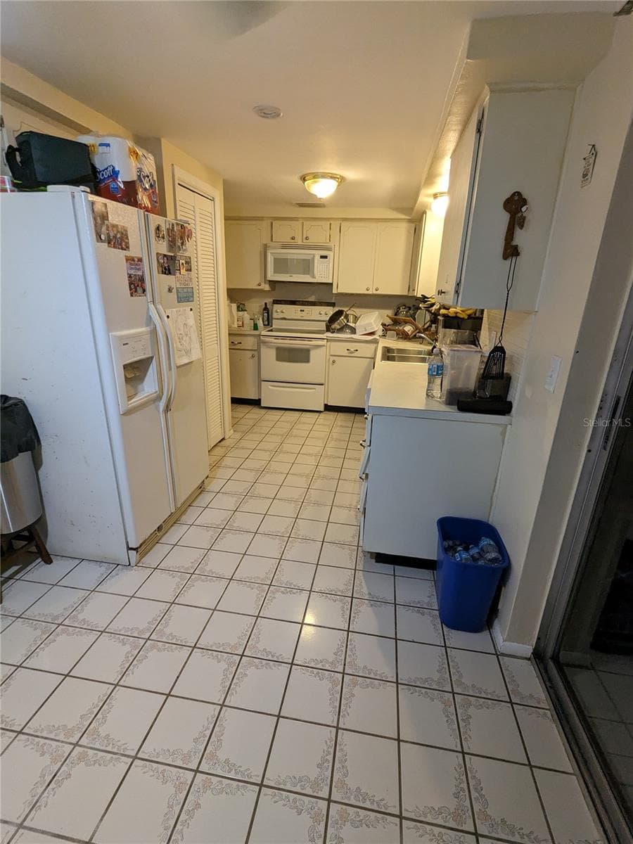 LG KITCHEN HAS EAT-IN AREA WITH SLIDERS TO ENCLOSED LANAI - 3937 SAIL DR, NEW PORT RICHEY