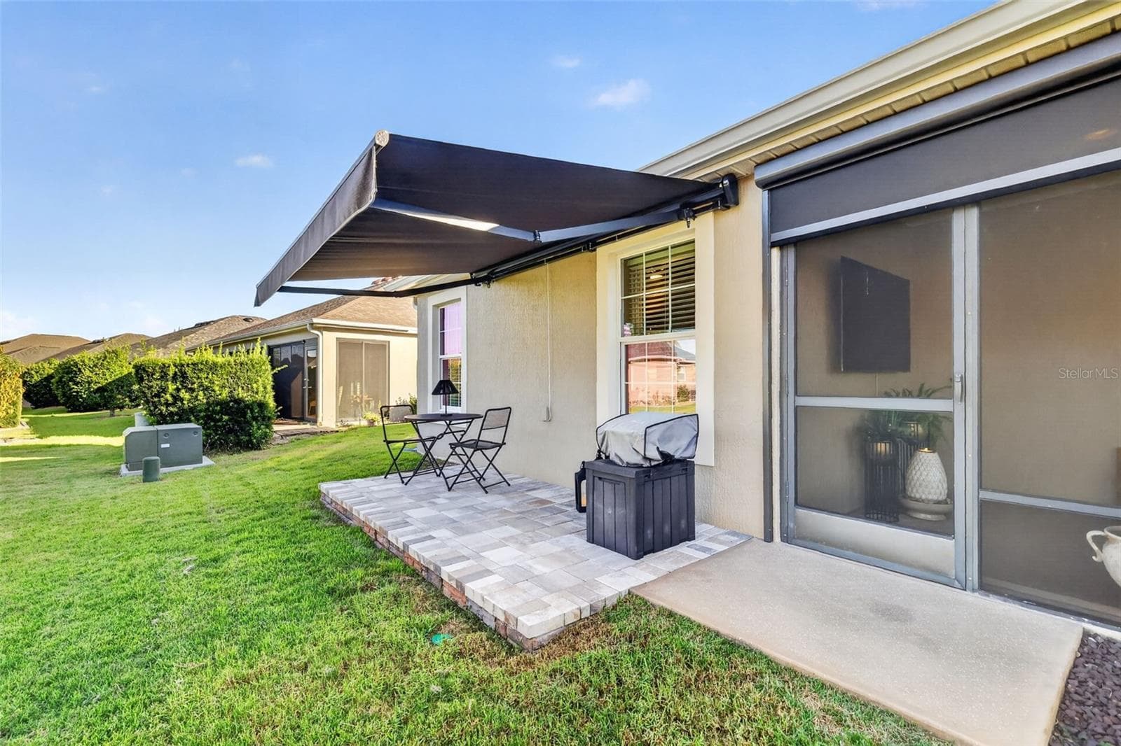 Side Paver Patio with Remote-Controlled Awning - 1793 WAX BERRY CT, THE VILLAGES