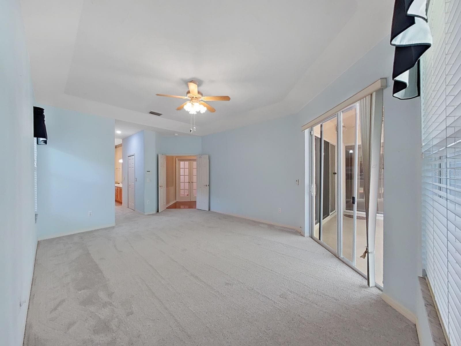 Primary Bedroom ~ Doors Open to Lanai - 14915 DEVONSHIRE WOODS PL, TAMPA