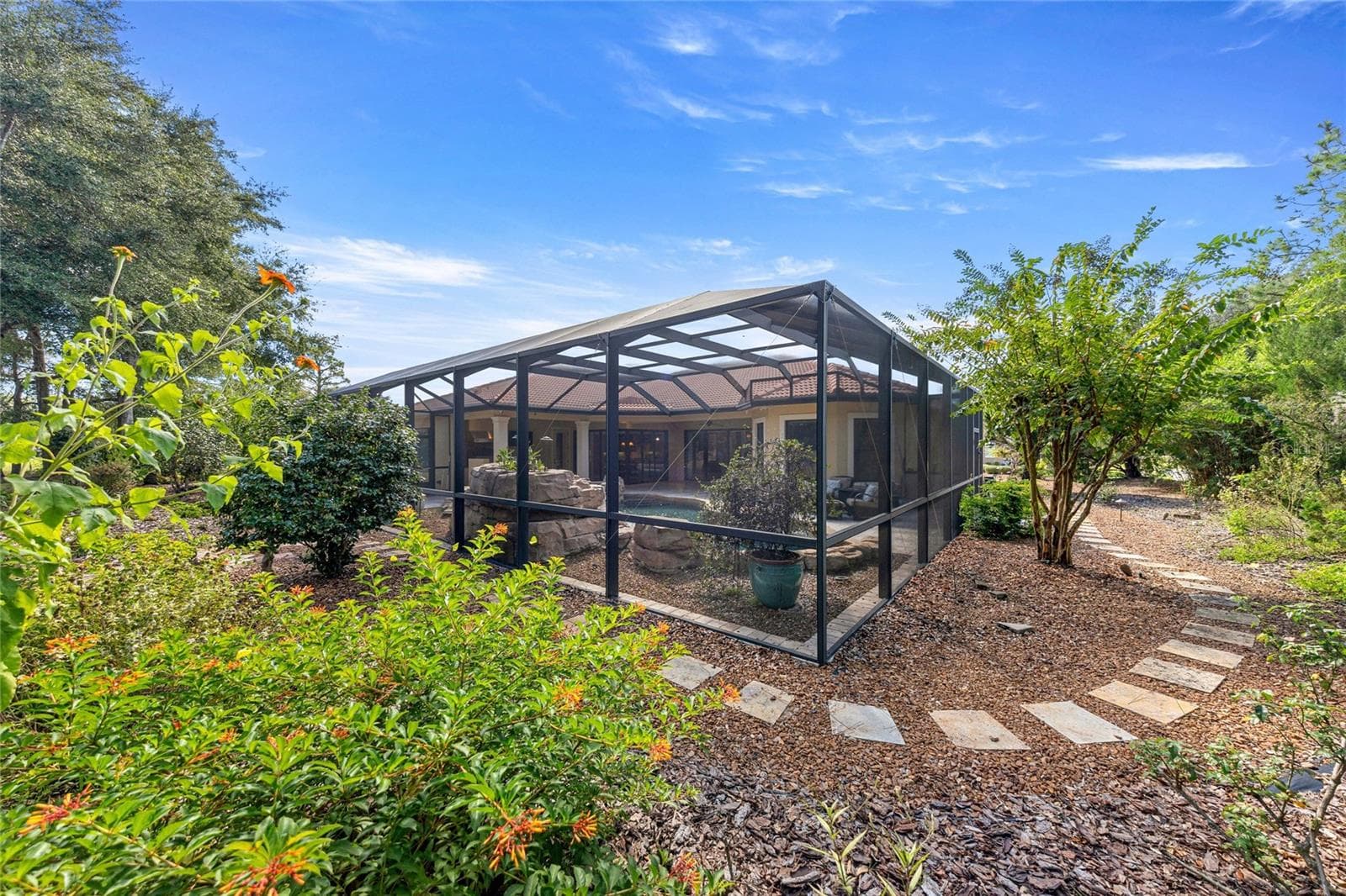 Side Yard – Mature trees, low-maintenance landscaping, and stone walkway. - 6501 SW 179TH AVENUE RD, DUNNELLON