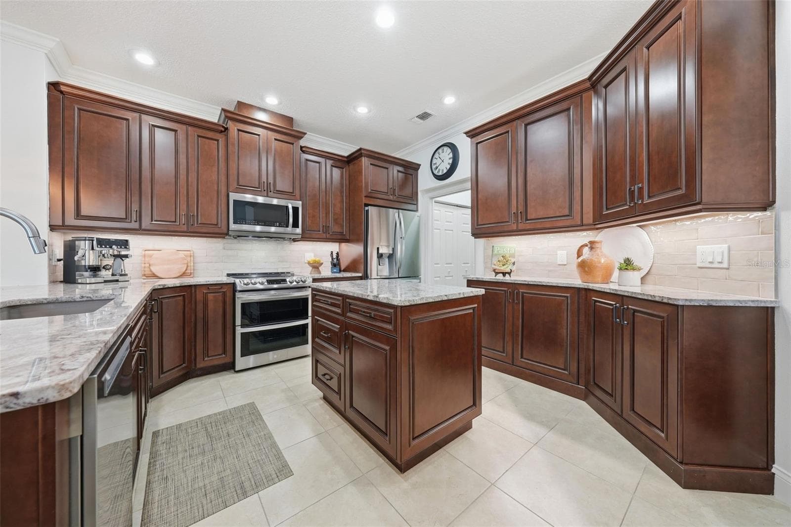 KITCHEN WITH CUSTOM SOLID WOOD CABINETS WITH PLENTY OF QUARTZ COUNTER SPACE - 13850 BLUEWATER CIR, ORLANDO
