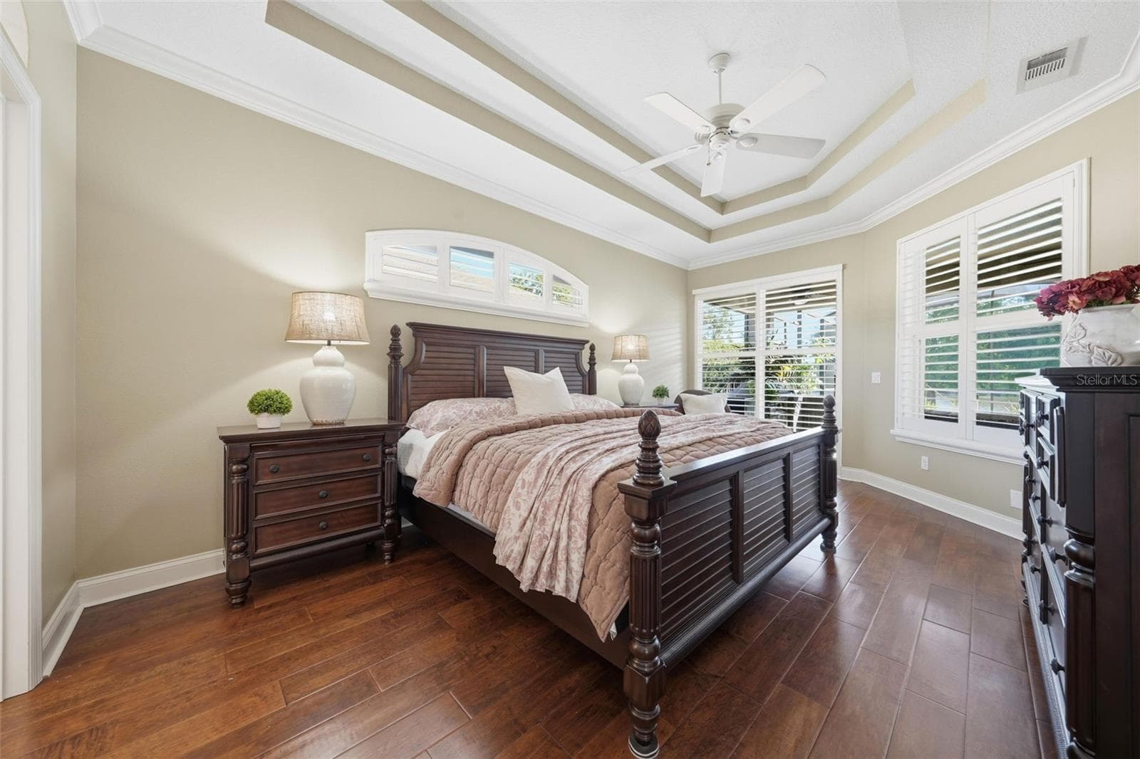 PRIMARY BEDROOM WITH DOUBLE TRAY CEILING AND SLIDING DOORS OUT TO THE POOL - 13850 BLUEWATER CIR, ORLANDO
