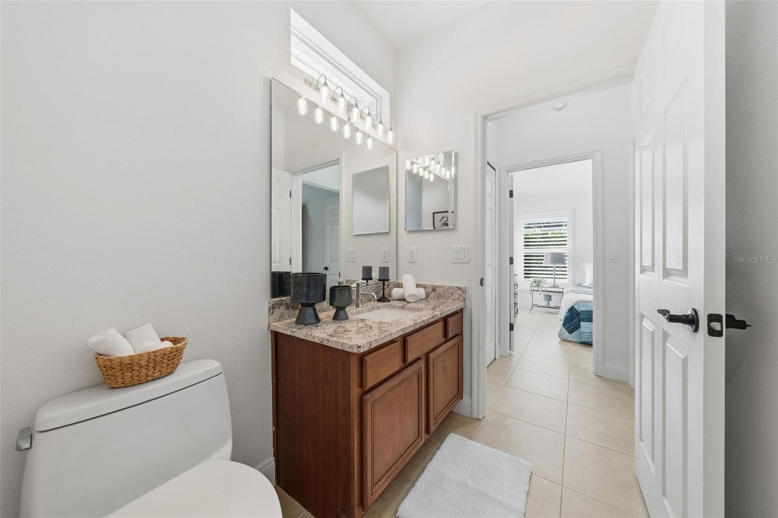 POOL BATH WITH 4TH BEDROOM IN THE BACKGROUND AND A DOOR SEPARATING FROM THE FAMILY ROOM - 13850 BLUEWATER CIR, ORLANDO