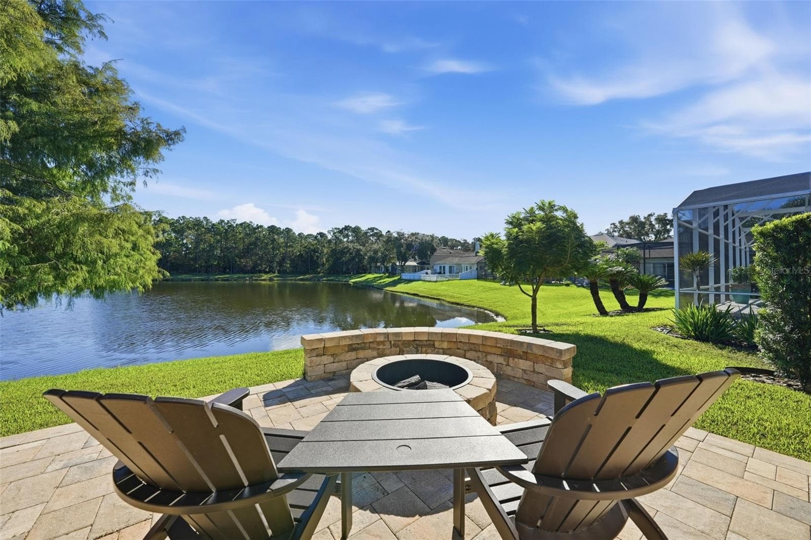 FIRE PIT ON THE PATIO OVER LOOKING THE POND WITH BUILT IN SEATING. LOOK AT THAT VIEW! - 13850 BLUEWATER CIR, ORLANDO