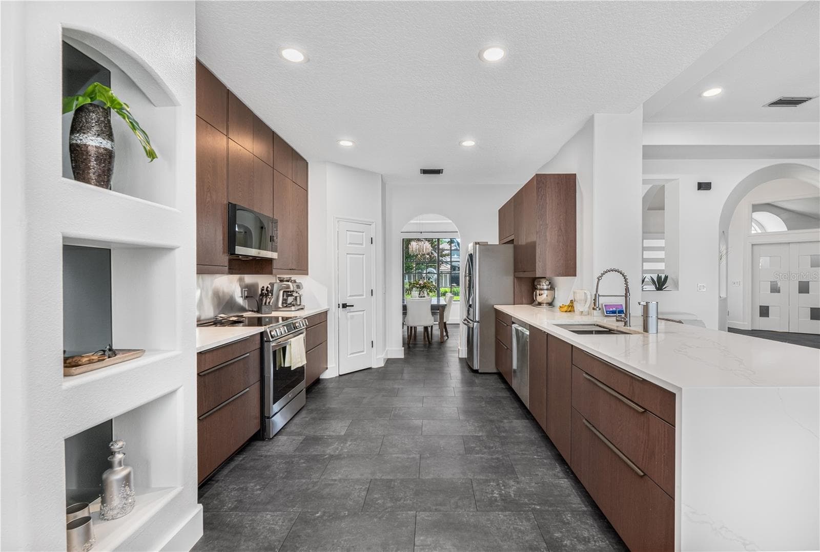Modern kitchen featuring beautiful cabinetry, waterfall quartz counters, and stainless steel appliances. - 1854 VISTA ROYALE BLVD, ORLANDO