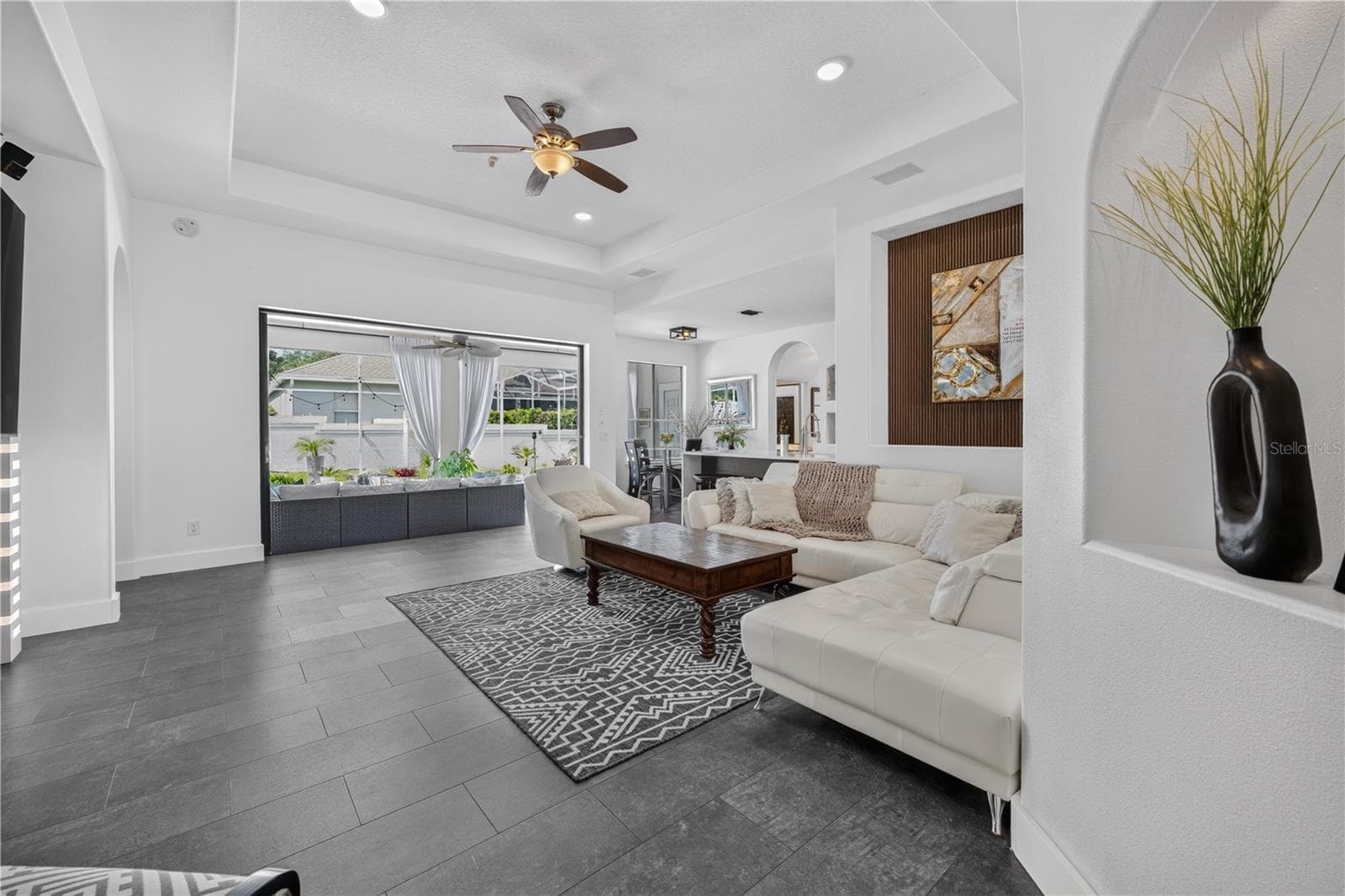 Expansive sliding glass doors open fully, seamlessly extending the living area to the outdoors and creating an ideal space for entertaining. - 1854 VISTA ROYALE BLVD, ORLANDO